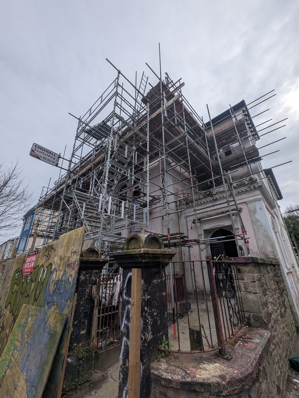 Mozarts as acquired, in scaffold with deteriorated render and joinery